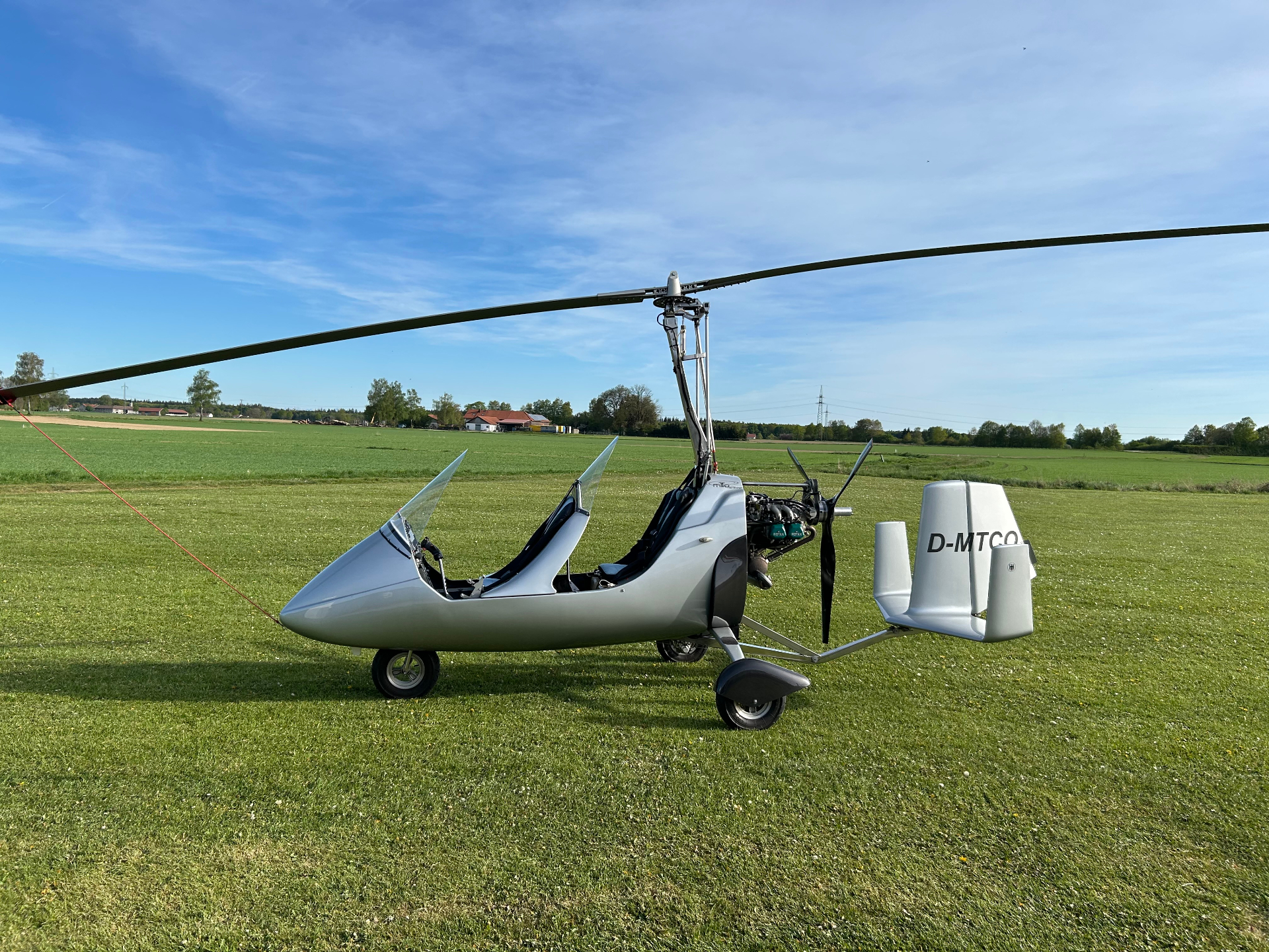 Silberner Gyrocopter auf der Startwiese